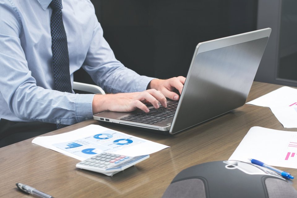 Schadebehandelaar werkt aan een dossier op een laptop